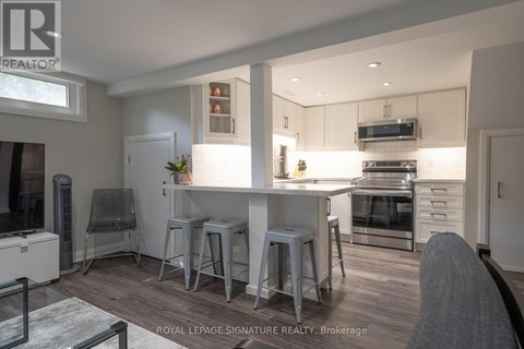 A modern kitchen with white cabinets and stainless steel appliances.