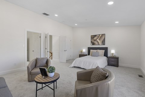 A bedroom with a bed, nightstands, and a chair.