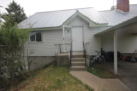 A house with a white door and a bicycle parked outside.