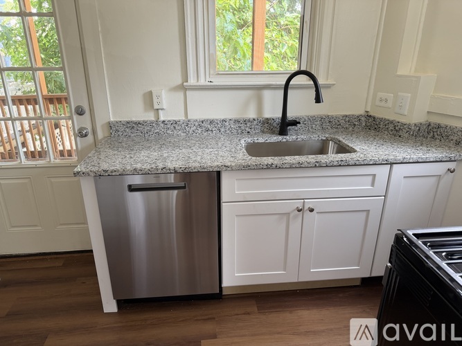 A kitchen with a granite countertop and stainless steel appliances.