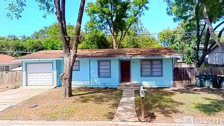 A blue house with a red door and a tree in front.