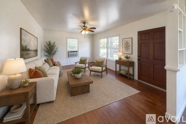 A living room with a couch, chairs, and a rug.