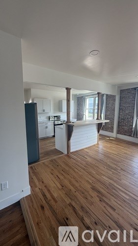 A kitchen with wooden floors and a dining area.