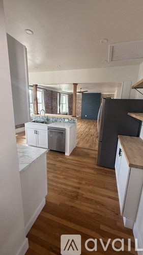 A kitchen with wooden floors and white cabinets.