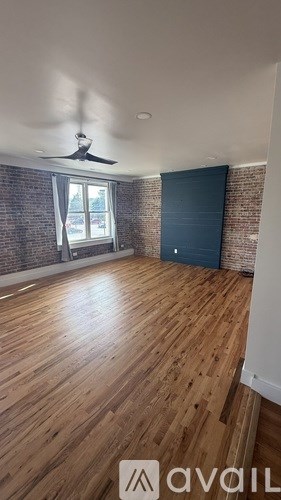 A room with wooden flooring and a ceiling fan.