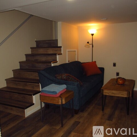 A living room with a couch, chair, and stairs.