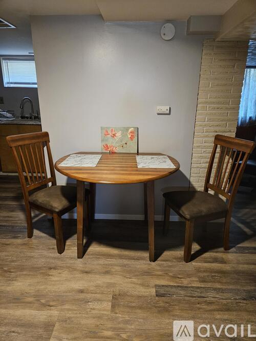 A dining room with a wooden table and chairs.