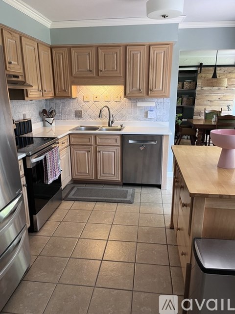 A kitchen with wooden cabinets and a tiled floor.
