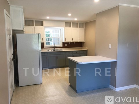 A kitchen with a refrigerator and a counter.