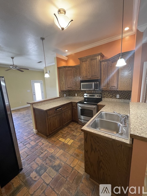 A kitchen with wooden cabinets and a tiled floor.