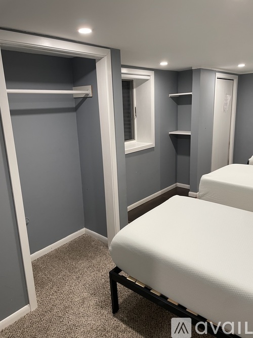 A bedroom with a bed, shelves, and a window.