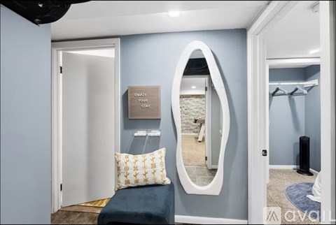 A mirror with a white frame is on the wall.