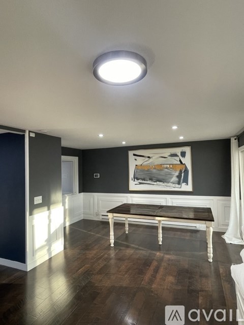 A modern living room with a bench and a painting on the wall.
