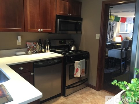 A kitchen with a black stove top oven and a black microwave above a dishwasher.