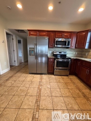 A kitchen with brown cabinets and a tile floor.