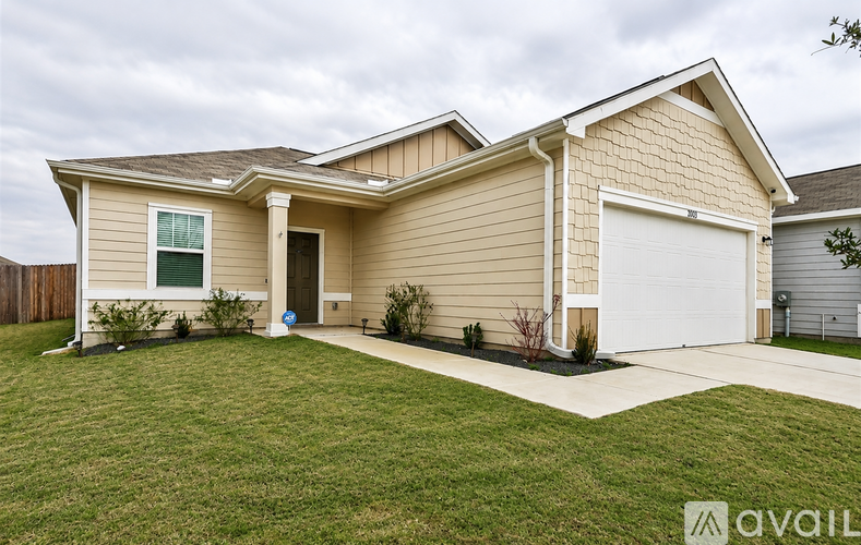 A beige house with a white garage door and a small front yard.