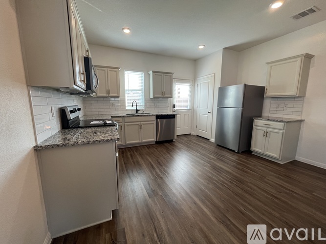 A kitchen with wooden floors and a granite countertop.