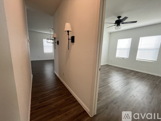 A hallway with wood floors and a ceiling fan.