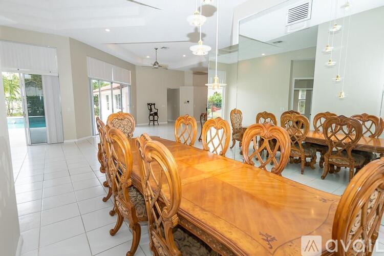 A wooden dining table with chairs in a spacious room.