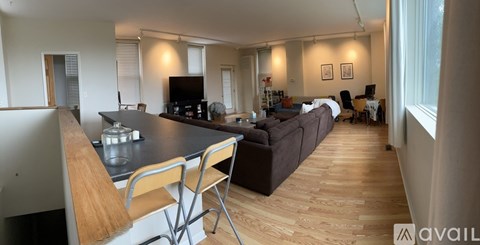 A modern kitchen with a wooden island and bar stools.