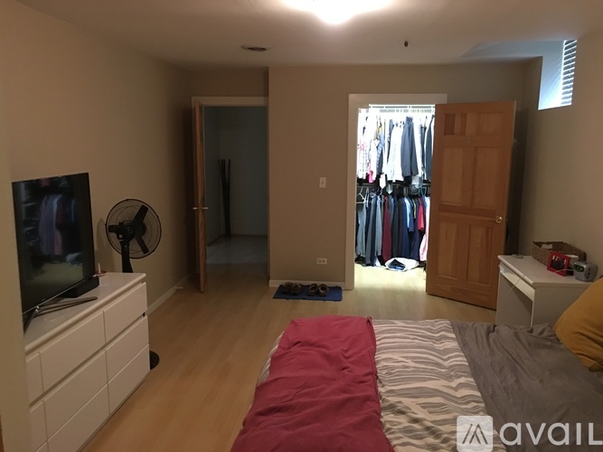 A bedroom with a bed, a dresser, a TV, a fan, and a closet.