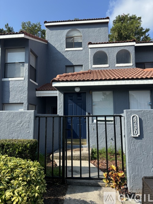 A house with a blue exterior and a black gate.