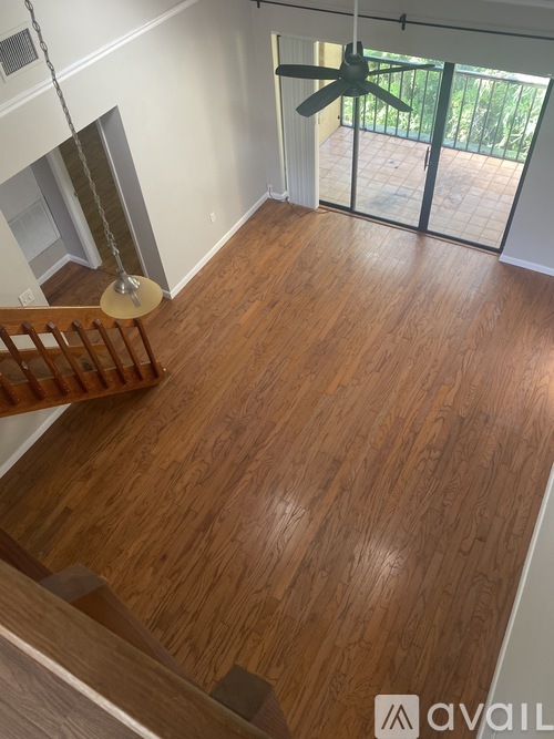 A room with wooden flooring and a ceiling fan.