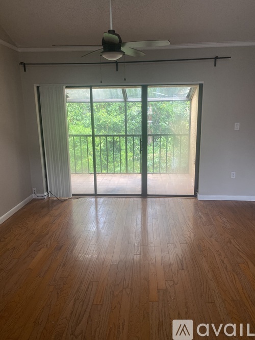 A room with wooden flooring and a ceiling fan.