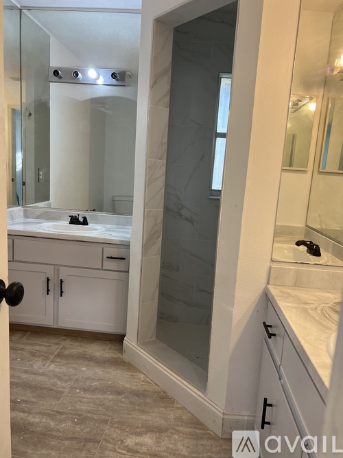 A bathroom with a walk-in shower and a vanity.