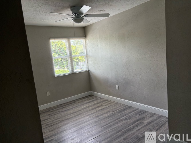 A room with a ceiling fan and a window.