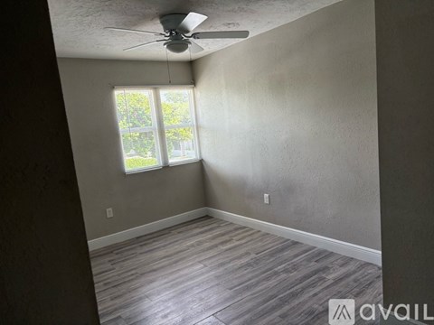 A room with a ceiling fan and a window.