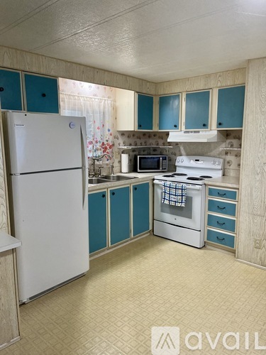 A kitchen with a white refrigerator and a white stove top oven.