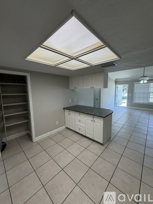 A kitchen with white cabinets and a black countertop.