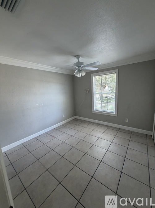 A room with a ceiling fan and a window.