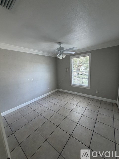 A room with a ceiling fan and a window.