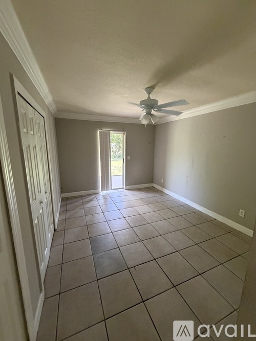A room with a ceiling fan and tiled floor.