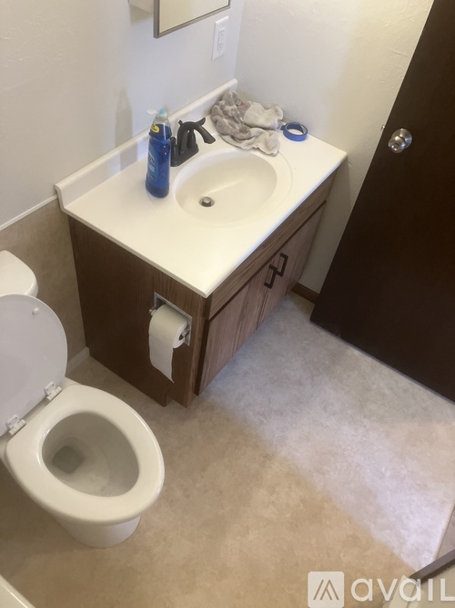 A bathroom with a toilet, sink, and mirror.
