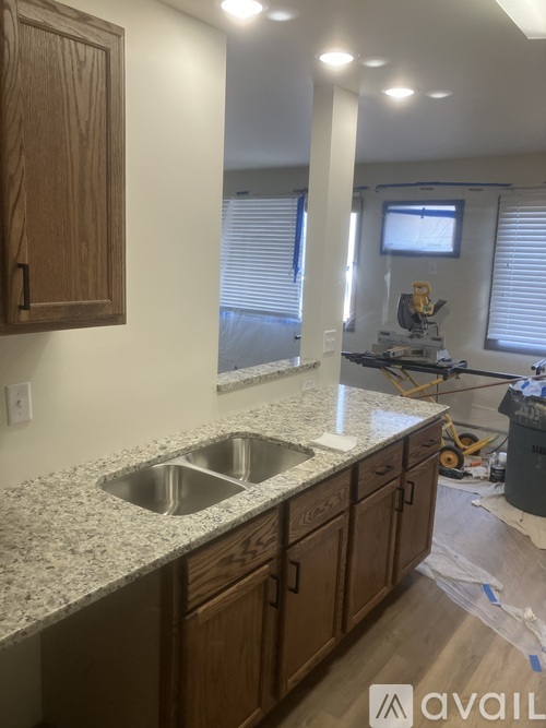 A kitchen under construction with wooden cabinets and granite countertops.