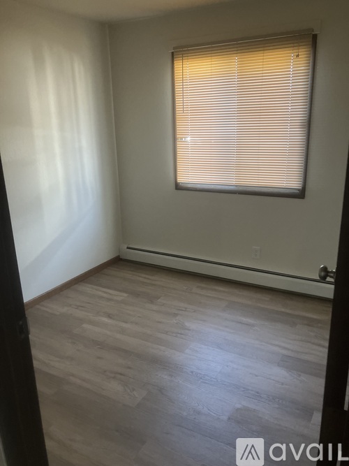 A room with a window and wooden flooring.