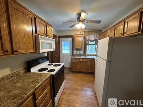 A kitchen with wooden cabinets and a granite countertop.