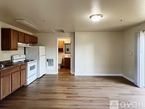 A kitchen with white appliances and wooden cabinets.