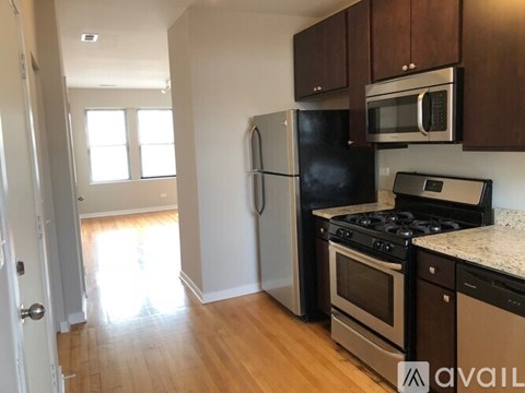 A kitchen with a black fridge, stove, and microwave.