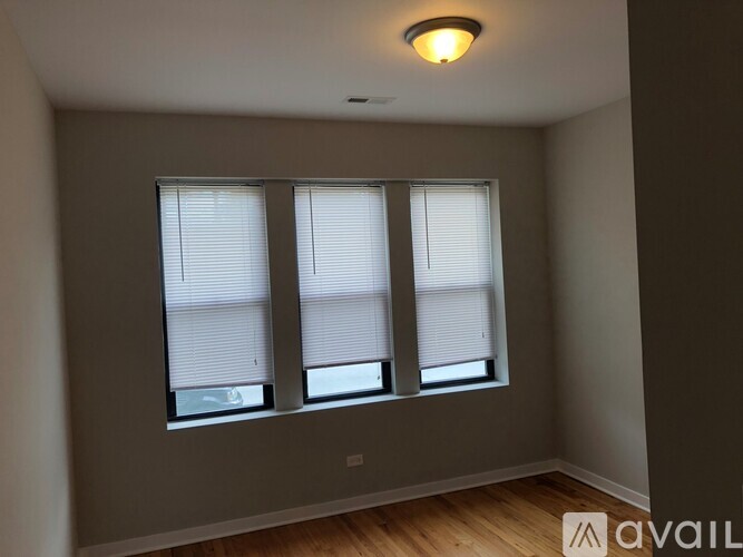 A room with a window and a wooden floor.