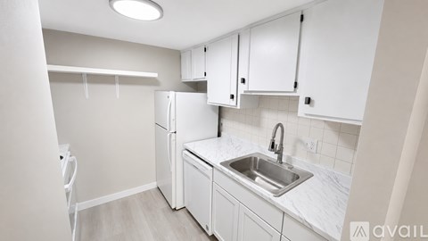 A kitchen with white cabinets and a marble countertop.
