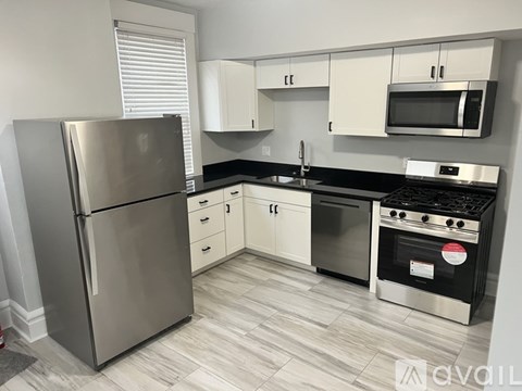 A kitchen with a stainless steel refrigerator, microwave, oven, and cabinets.