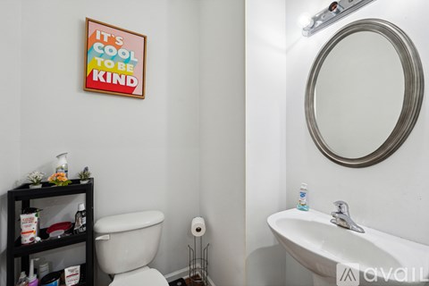 A bathroom with a poster that says "It's cool to be kind".