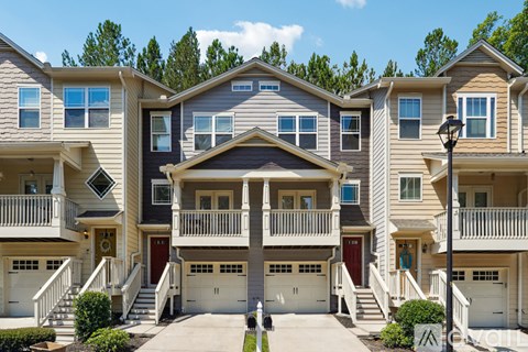 A row of townhouses with balconies and garages.