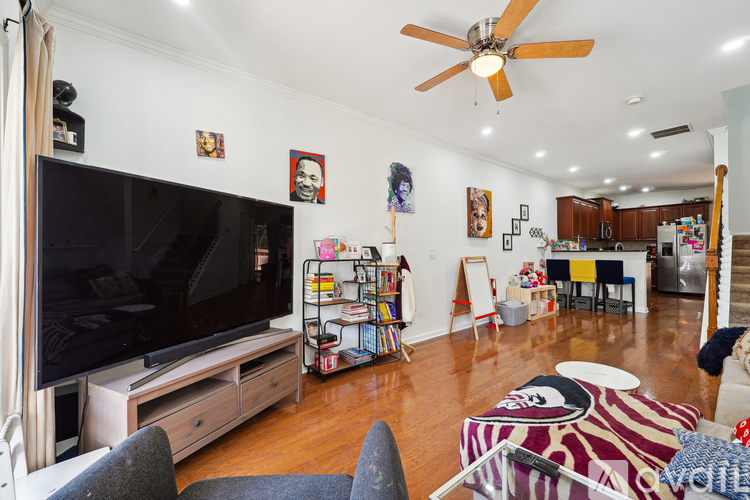 A living room with a television and a fan.