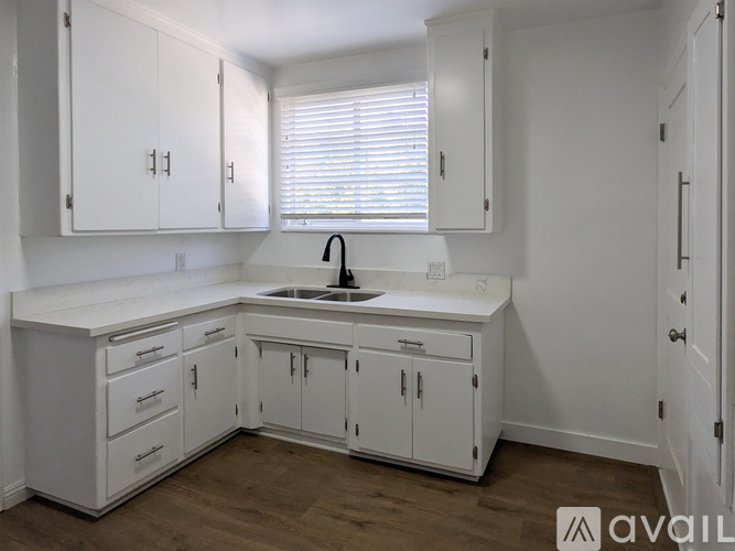 A kitchen with white cabinets and a sink.