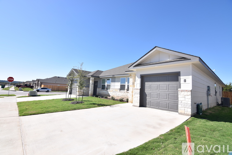 A house with a garage and a driveway in front of it.